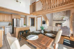 Una cocina y un comedor con mesa y sillas de madera. en Spa Pool table Mountain view - Martine-54, en Petite-Rivière-Saint-François