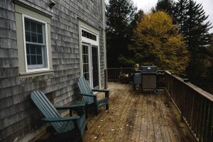 2 sedie sedute su una terrazza con griglia di Gorgeous Green Mountain Retreat for a Family Vacation in Vermont a Mount Holly