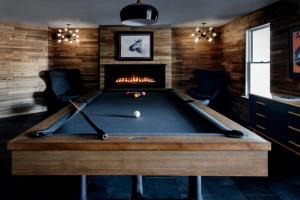 ein Billardtisch in einem Raum mit Kamin in der Unterkunft Gorgeous Green Mountain Retreat for a Family Vacation in Vermont in Mount Holly
