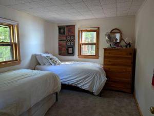 - une chambre avec 2 lits et une commode en bois dans l'établissement Quaint Lakeside Cabin for a Peaceful Family Getaway Surrounded by Nature by Province Lake in New Hampshire, à Ossipee