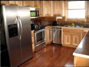 Una cocina con refrigerador de acero inoxidable y gabinetes de madera. en Rustic Log Cabin For a Group Getaway near Lake Cumberland in Kentucky, en Liberty