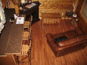 sala de estar con mesa y sofá de cuero en Rustic Log Cabin For a Group Getaway near Lake Cumberland in Kentucky, en Liberty