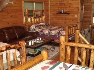 una sala de estar con una cama y un sofá en Rustic Log Cabin For a Group Getaway near Lake Cumberland in Kentucky, en Liberty 18 fotos más