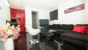 a living room with a couch and a tv at Villa Baneheia in Kristiansand