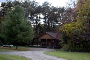 a log cabin in the middle of a forest at Secluded Log Cabin with a Hot Tub near Bridle Trails in Logan, Ohio in Cedar Grove