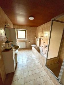a bathroom with a tub and a toilet and a sink at Frisch renovierte Ferienwohnung in Bad Schönborn in Bad Schonborn