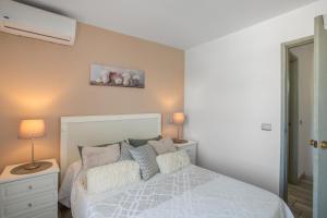 Un dormitorio con una cama con dos mesitas de noche y dos lámparas. en Great Bungalow Maspalomas, en Maspalomas 16 fotos más