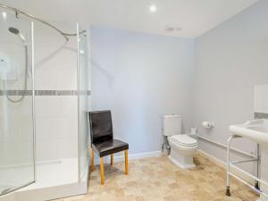 a bathroom with a toilet and a black chair at 3 Bed in Bruton HTORV in Castle Cary +11 photos