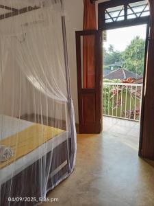 a bedroom with a bed and a door to a balcony at Villa Auro in Hikkaduwa