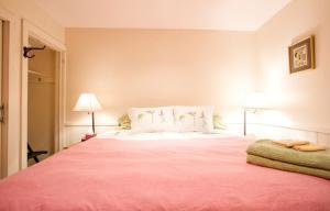Stratton MountainにあるBed and Breakfast Nature Lodge with a Yoga Studio on Stratton Mountain, Vermontのベッドルーム1室(大型ピンクベッド1台、ランプ2つ付)