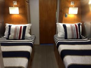 two beds in a room with two lamps on the wall at Classy Airstream Land Yacht Rental with Modern Amenities near Gatlinburg, Tennessee in Shady Grove +26 photos