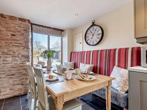 a dining room with a table and a clock on the wall at 3 Bed in Leominster 50513 in Pencombe