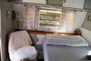 En eller flere senge i et værelse på Texas Hill Country Vintage Caravan Glamping