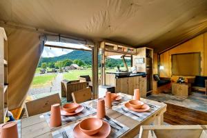 a dining room with a table with bowls on it at Beautiful Secluded Tented Cabin with Fire Pit in Sevierville, Tennessee in Wear Valley