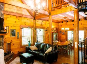 een woonkamer met een leren bank en een tafel bij Log Cabin Rental with a Porch near Shenandoah National Park, Virginia in Grove Hill