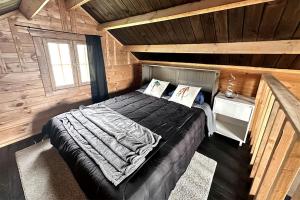 a bedroom with a bed in a wooden cabin at Solar Powered Lakefront Twin Tiny Houses in Cantwell Alaska, Perfect for a Group Getaway to Denali National Park in Cantwell
