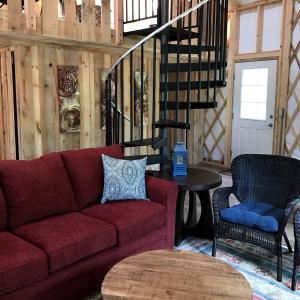 un salon avec un canapé rouge et une table dans l'établissement Gorgeous Yurt Rental for a River Vacation near Roanoke, Virginia, à Rich Creek