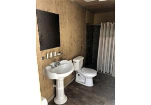 a bathroom with a sink and a toilet and a mirror at Oklahoma Glamping in this Wonderful Covered Wagon for Family Vacations near Oklahoma City in Moore