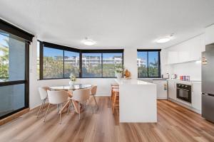 Una cocina y un comedor con mesa y sillas. en SaltHaus - Luxurious coastal escape 100m to beach, en Alexandra Headland