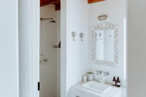 un bagno bianco con lavandino e specchio di Harmony House a Paternoster