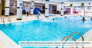a large swimming pool with people playing in it at Willa Port in Mikołajki