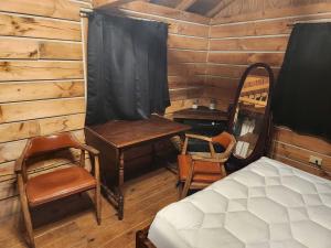 a bedroom with a bed and a desk and a table at Rural Cabin with Fire Ring Perfect for Outdoor Activities in Indiana in Stony Lonesome