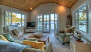 ein Wohnzimmer mit Sofa, Sesseln und Fernseher in der Unterkunft All Dream Cottages Romantic Island Getaways in Orcas