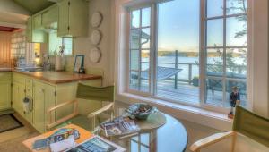 eine Küche mit einem Tisch und einem großen Fenster in der Unterkunft All Dream Cottages Romantic Island Getaways in Orcas + 11 Fotos