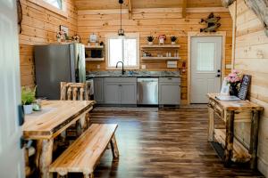 eine Küche mit Holzwänden und Tischen sowie einem Kühlschrank in der Unterkunft Rustic Wooden Cabin with Hot-tub in Campbellsville, Kentucky in Campbellsville