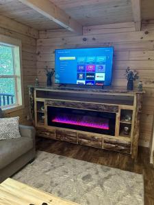 a living room with a tv and a fire place at Rustic Wooden Cabin with Hot-tub in Campbellsville, Kentucky in Campbellsville