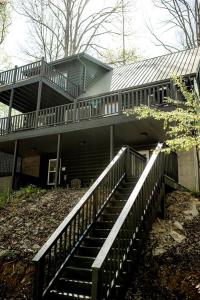 ein Haus mit einer Treppe, die zu einem Gebäude führt in der Unterkunft Rustic Wooden Cabin with Hot-tub in Campbellsville, Kentucky in Campbellsville