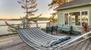 eine Hängematte auf der Terrasse eines Hauses in der Unterkunft All Dream Cottages Romantic Island Getaways in Orcas