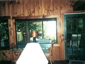 Cette chambre dispose d'une table en verre et d'une fenêtre. dans l'établissement Nestled Camping Cabin Rental Overlooking Lake near Glens Falls, New York, à Severance