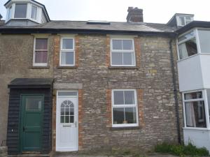 an old brick house with a green door at 2 Bed in Langton Matravers DC068 in Langton Matravers