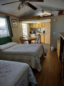 a bedroom with two beds and a table and a kitchen at Comfy Vacation Rental with Wi-Fi and Kitchenette in Meadview, Arizona in Meadview