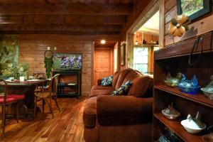 a living room with a couch and a table at Charming Appalachian Mountain Cabin for Glamping near the Nantahala River in Aquone