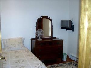 1 dormitorio con cama, espejo y TV en Lovely Cottage Getaway in the Mountains near Phoenicia, New York, en Chichester