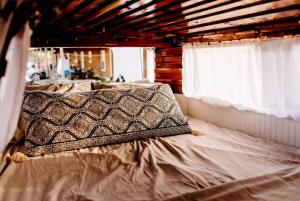 a bed with a pillow on it with a window at Refurbished Campervan Rental Perfect for Glamping in Missouri in Saint Clair
