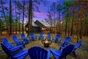 a group of chairs around a fire in front of a cabin at Incredible Spacious Cabin Surrounded by Nature for an Amazing Escape for the Whole Family in Broken Bow, Oklahoma in Mount Herman