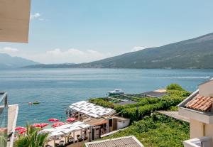 a view of a body of water with buildings and umbrellas at Beachfront Bliss in Đenovići