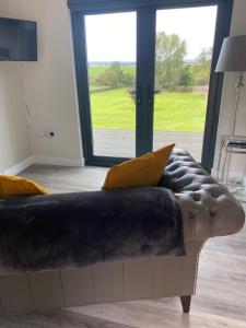 a couch in a living room with a large window at Danielle’s den in Doncaster
