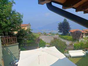 a white umbrella sitting on top of a yard at Villa Bruna by Holiday World in Pisogne