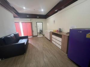 a living room with a couch and a kitchen at Komol Residence Bangkok in Bangkok
