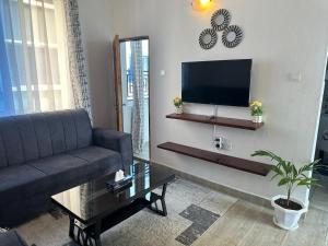 a living room with a couch and a flat screen tv at JO Apartment in Malindi +3 photos
