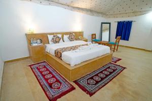 Un dormitorio con una cama grande y una mesa y sillas. en Desert Sam Dunes Camp, en Sām 8 fotos más