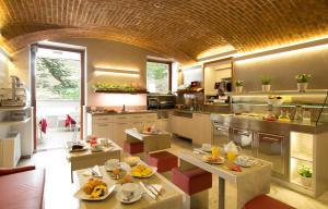 une grande cuisine avec des tables et des chaises. dans l'établissement Hotel Ideale, à Milan