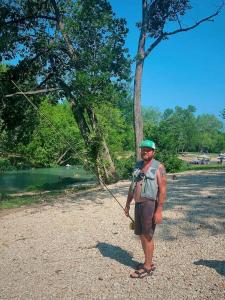 a man flying a kite in a park at Fun Glamping Destination for All: Luxurious Safari Tent on the San Marcos River near Kingsbury, Texas in Staples