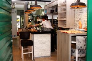 a chef preparing food at a counter in a restaurant at Vila Bilo in Primošten