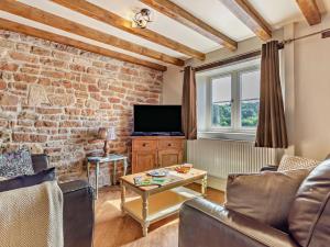 Greasleyにある2 Bed in Newthorpe 47031のレンガの壁、テレビ付きのリビングルーム