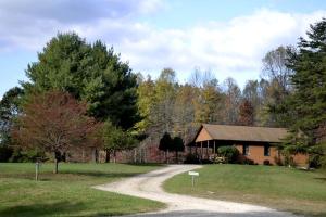 ein Haus mit Schotterstraße vor einem Haus in der Unterkunft Log Cabin Rental with Hot Tub near Hocking Hills State Park in Ohio in Cedar Grove